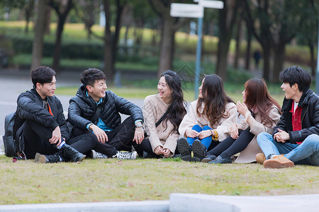 青年大学生青年聚会围坐在草地上背景