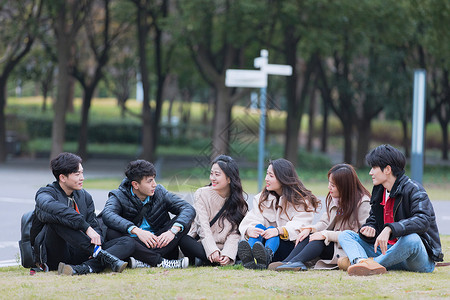 团队城市青年聚会围坐在草地上背景