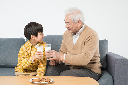 吃饼干男孩祖孙沙发上喝牛奶吃早餐背景