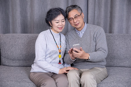视频娱乐一起玩手机的老年夫妻背景