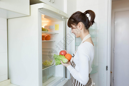 冰箱贴从冰箱里拿果蔬的家庭主妇背景