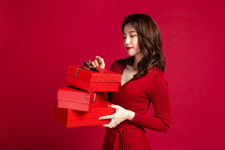 女性手拿红色礼品盒背景图片