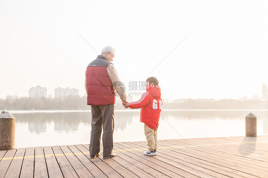 祖孙情夕阳下爷爷牵孙子背影图片