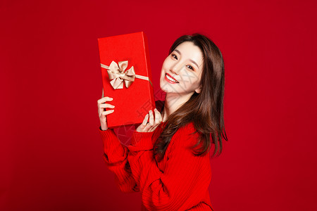 时尚美女手拿红色礼盒背景图片