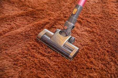 红色吸尘器吸尘器清洁地毯特写背景