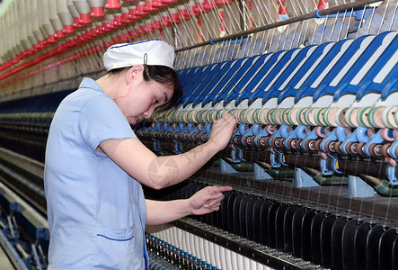  纺织工人检查纺纱机图片