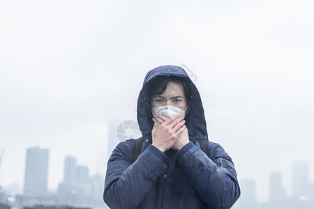 在雾霾中捂住口鼻背景图片