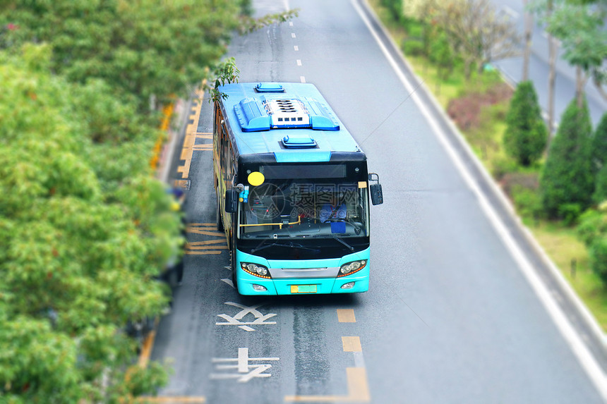 马路上的一辆蓝色的公交车大巴车
