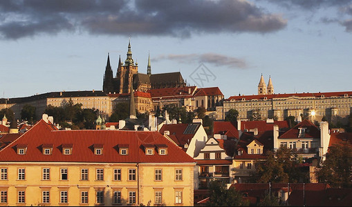 在早上沐浴在金色阳光下的布拉格城堡区建筑背景