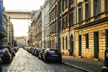 沐浴在早晨金色阳光下的布拉格街头建筑背景图片