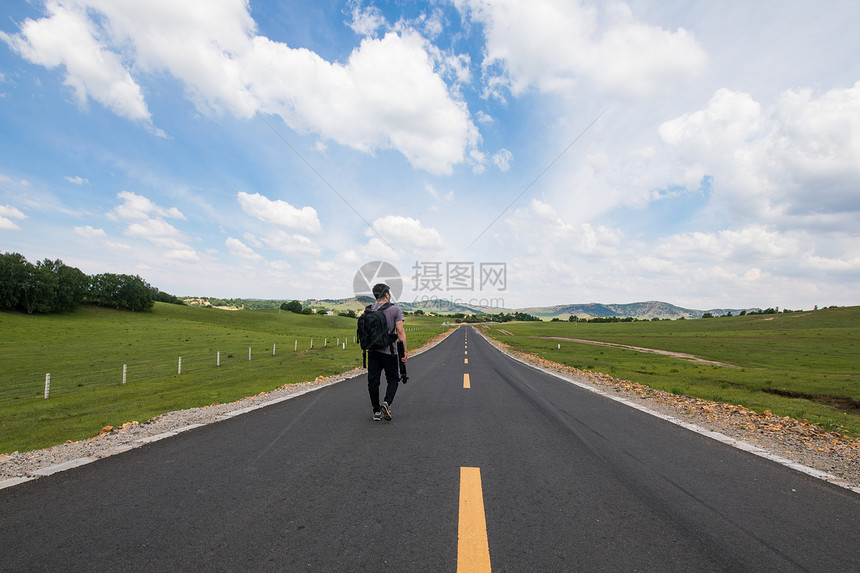 行走在道路上的旅行者图片