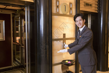酒店服务员为顾客开电梯工作高清图片素材