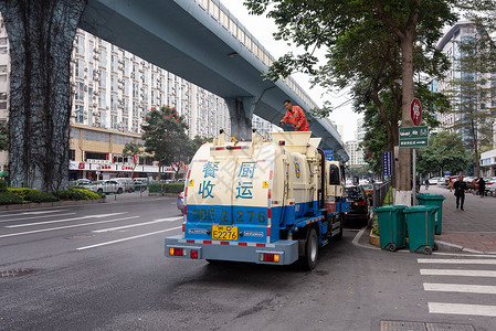 辛勤工作的劳动者 环卫工人站在路边的餐余垃圾收运车图片