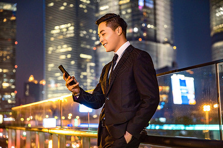 天桥夜景年轻商务男子天桥玩手机背景