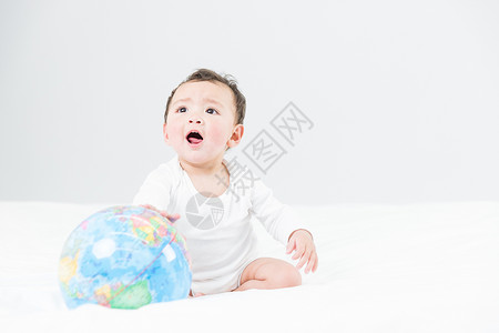 婴儿坐在地球婴儿教育和地球仪背景