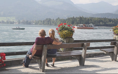 坐在欧洲著名度假区沃尔夫冈湖区情侣背影高清图片