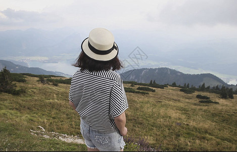 站在山顶看风景的女人背影白色草帽高清图片素材