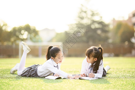 儿童节小学生趴在操场学习图片