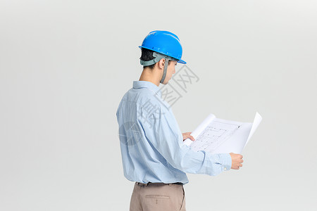 戴安全帽看图纸的工程师背景图片