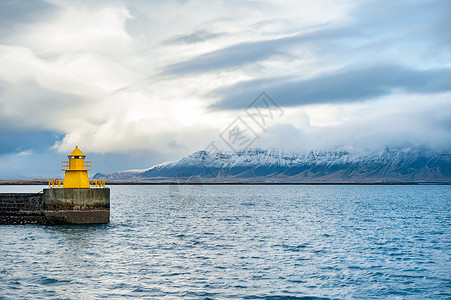 冰岛北冰洋大海雪山海岛黄色灯塔背景