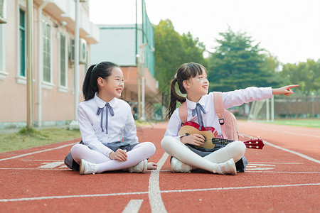 女生弹琴儿童节小学生操场弹琴背景