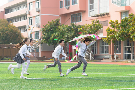 小学生操场活动儿童节小学生追逐放风筝背景