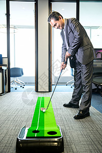 商务男士办公室打高尔夫背景图片
