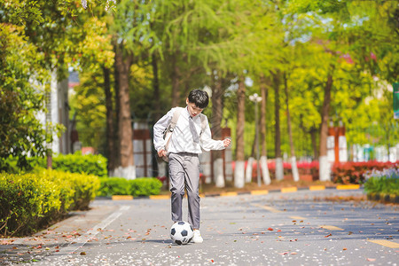 小男孩放学踢足球图片