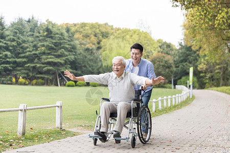 老年父子开心推轮椅背景图片