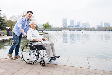 老年父子推轮椅背景图片