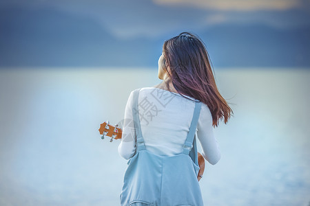 弹吉他女人女孩休闲看海弹吉他背景背景