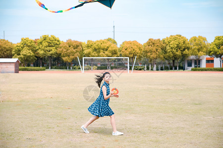 小女孩操场放风筝背景图片