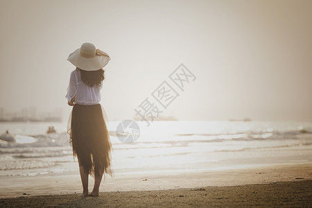 夕阳下海边看海女孩背景图片