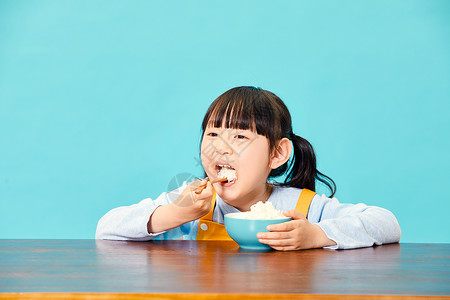 大儿童小女孩大口吃米饭背景