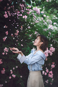 接露珠的女孩美女伸手接花瓣背景