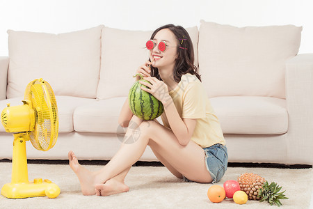 青年女子在客厅吹风扇降温高清图片素材