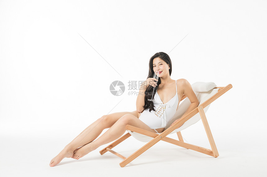 泳装美女在躺椅上喝香槟图片