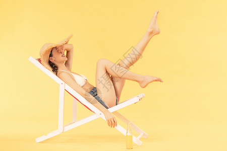夏季比基尼泳装青年女子沙滩椅乘凉背景