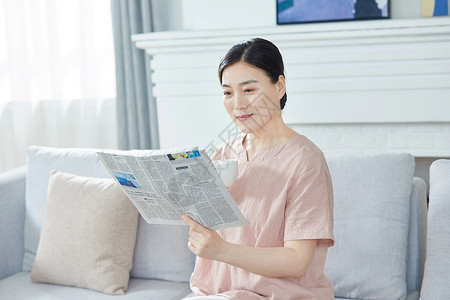 中年女性在家看报纸家庭妇女高清图片素材
