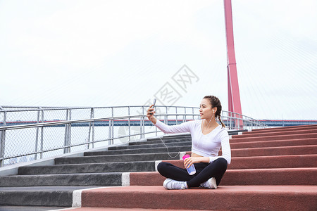 运动女性休息玩手机背景