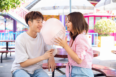 吃棉花糖女孩情侣游乐园吃棉花糖背景