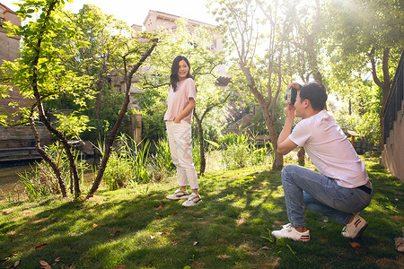 情侣在树林拍照背景图片