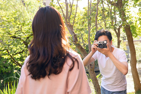 情侣在树林拍照背景图片