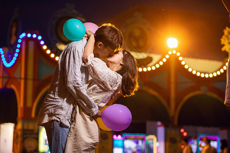 情侣游乐园夜景亲吻男性高清图片素材