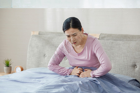 女性坐着中年女性腹痛背景