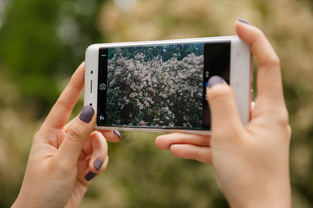 女性郊游拍照手机特写图片