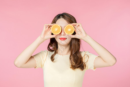 青年女性拿着橙子背景图片