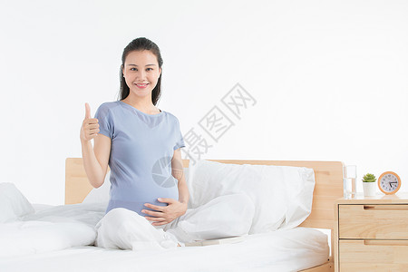 孕妇点赞孕妇坐床上休息背景