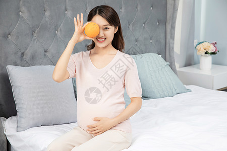 孕妇拿着橙子背景图片