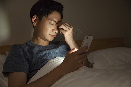 躺床上玩手机男子熬夜玩手机背景